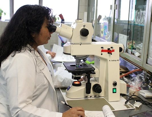 Photo of a scientist using a microscope