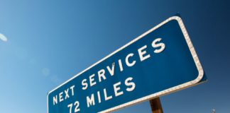 Photo of desert highway sign that reads Next Services 72 miles