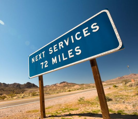 Lack of infrastructure holding back electric vehicles. Photo of desert highway sign that reads Next Services 72 miles