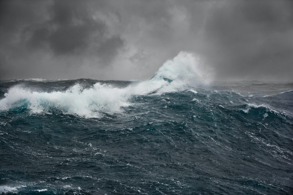 Photo of ocean waves and dark storm clouds