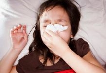 Photo of a sick child blowing her nose