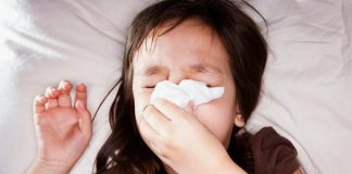 Photo of a sick child blowing her nose