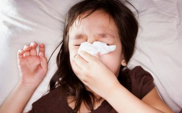 Photo of a sick child blowing her nose