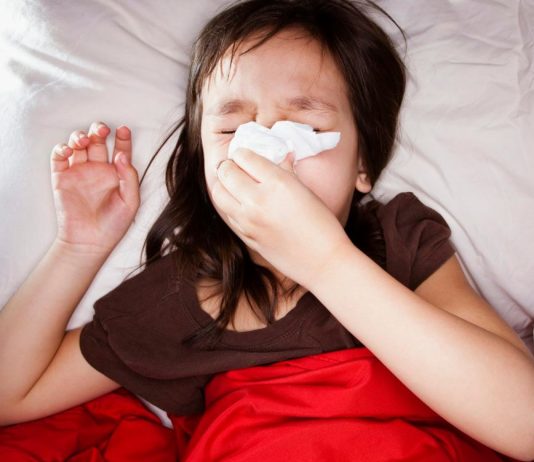 Photo of a sick child blowing her nose