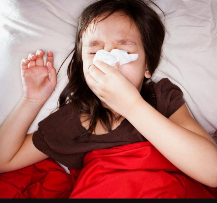 Photo of a sick child blowing her nose