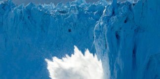 Photo of an iceberg breaking off of a glacier